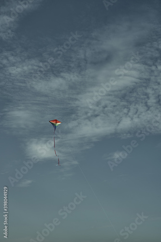 Beautiful kite in the sky against the background of clouds. Passion and hobby. Spending time in nature.