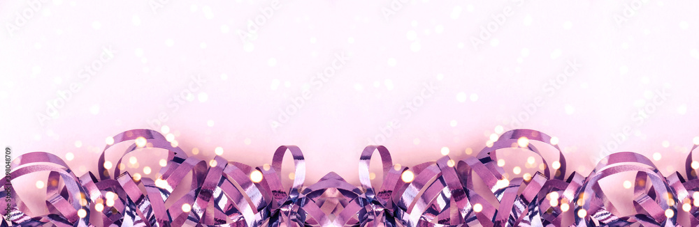 Banner with shiny violet ribbons, lights on a pink background. Christmas background. Festive concept. Banner with shiny violet ribbons, lights on a pink background. Christmas background. Festive concept.
