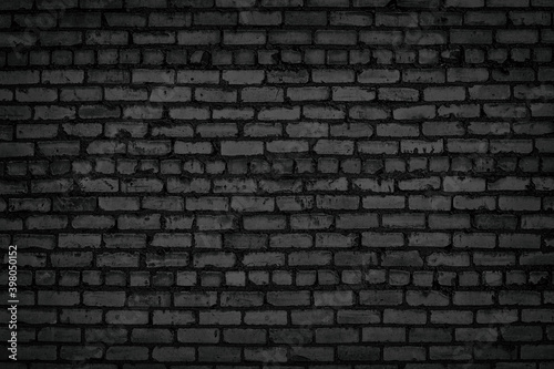 Black old brick wall texture. Rough block masonry. Gloomy grunge dark brickwork background