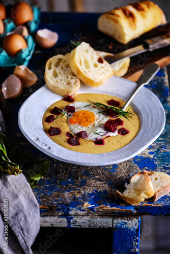 Cream of potato soup with beetroot and fried eggs.style rustic.