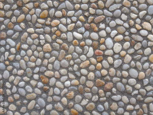 Colorful and round stones, stone wall texture, road made of small boulders and sea stones.