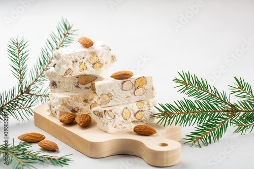 Torrone - soft italian nougat with almonds. Winter decoration. White background. photo