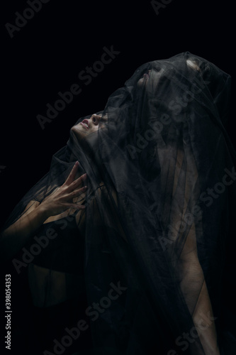Mystery. Graceful classic ballet dancers isolated on black studio background. Couple in minimalistic dark cloth look graceful, inspired. The grace, artist, movement, action and motion concept.