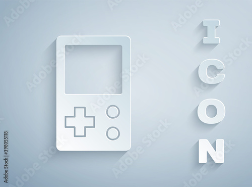 Paper cut Portable tetris electronic game icon isolated on grey background. Vintage style pocket brick game. Interactive playing device. Paper art style. Vector.