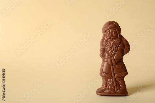 Sweet chocolate Santa Claus candy on beige background  space for text