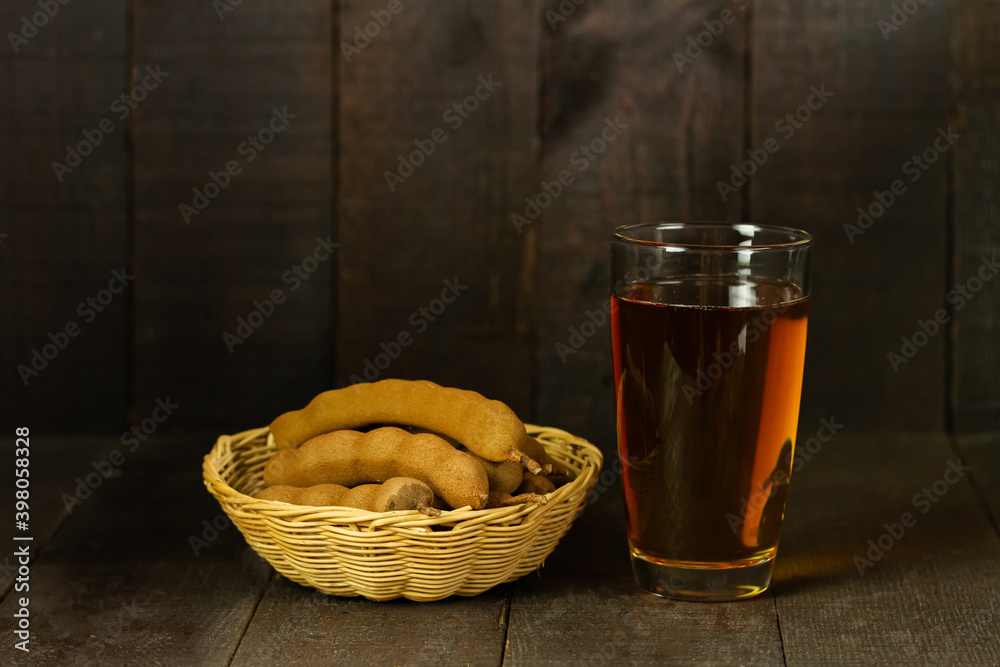 tamarind juice and tamarind fruit in wicker basket on wooden background copy space tamarind juice and tamarind fruit in wicker basket on wooden background copy space