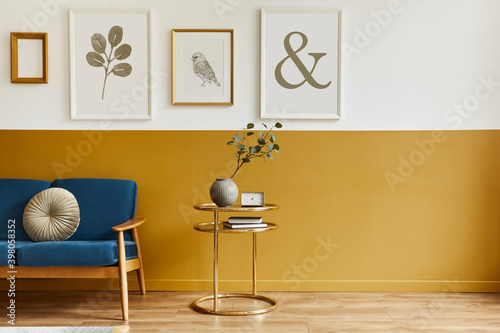 Unique living room in modern style interior with design sofa, elegant gold coffee table, mock up poster frames, flowers in vase, decoration and pesronal accessories in home decor. Template.