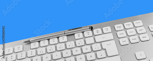 Keyboard and pen against blue background photo