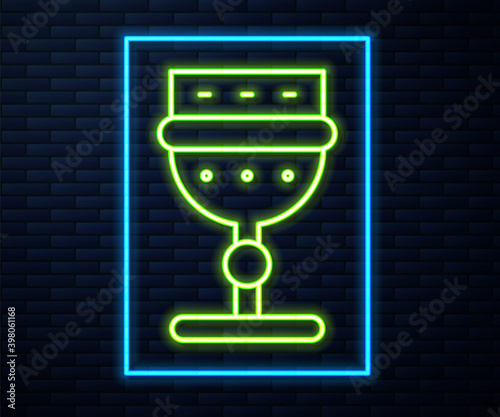 Glowing neon line Medieval goblet icon isolated on brick wall background. Vector.
