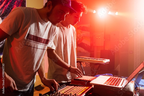 Disc jockeys or DJ stands behind the sound mixing console, makes sound at the party
