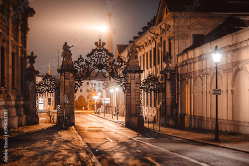 An empty archway at night above a street. The scenery is illuminated by yellow street lamps.