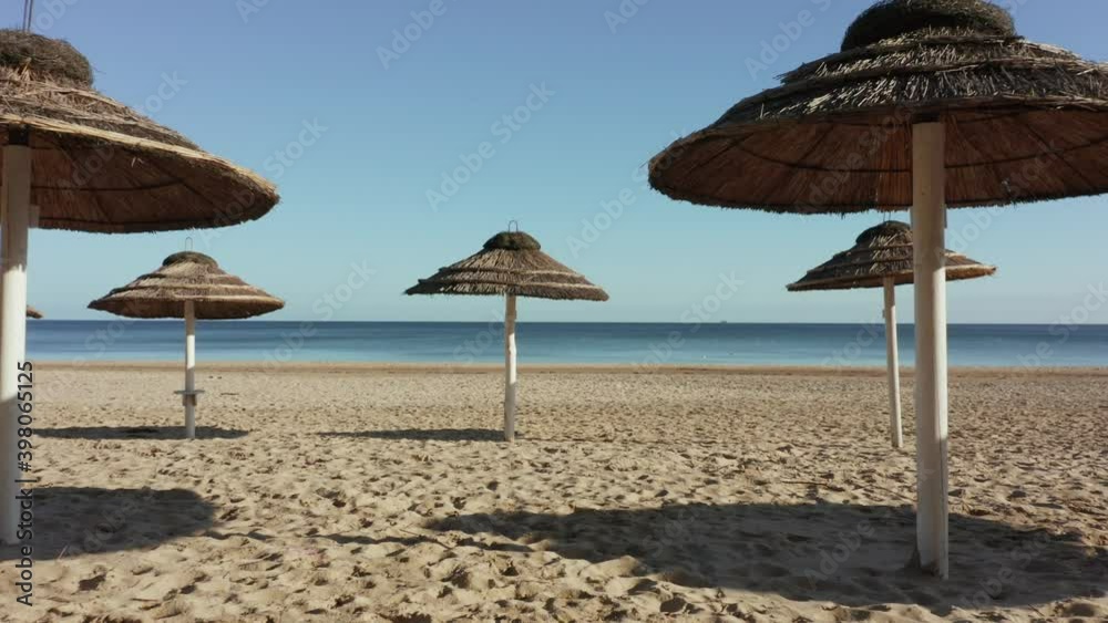 Drone shot on the beach with tropical umbrellas from the sun without people on a sunny autumn day. Drone shot on the beach with tropical umbrellas from the sun without people on a sunny autumn day.