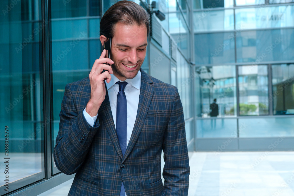 Happy young businessman chatting on his cell phone Happy young businessman chatting on his cell phone