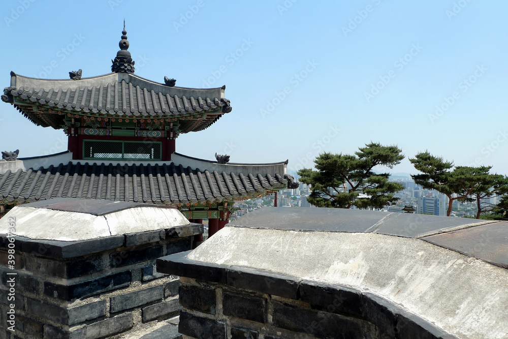 The roof of an ancient traditional Korean dwelling with the modern city Seoul in the background