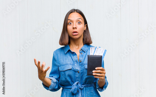 young hispanic woman open-mouthed and amazed, shocked and astonished with an unbelievable surprise