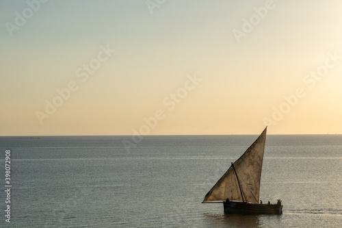 Canvas Print Wooden sailboat on the clear water of Zanzibar island during sunset
