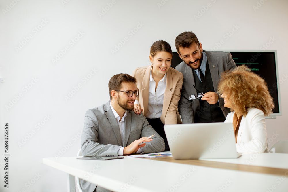 Fototapeta premium Group of young business people working and communicating while sitting at the office desk together