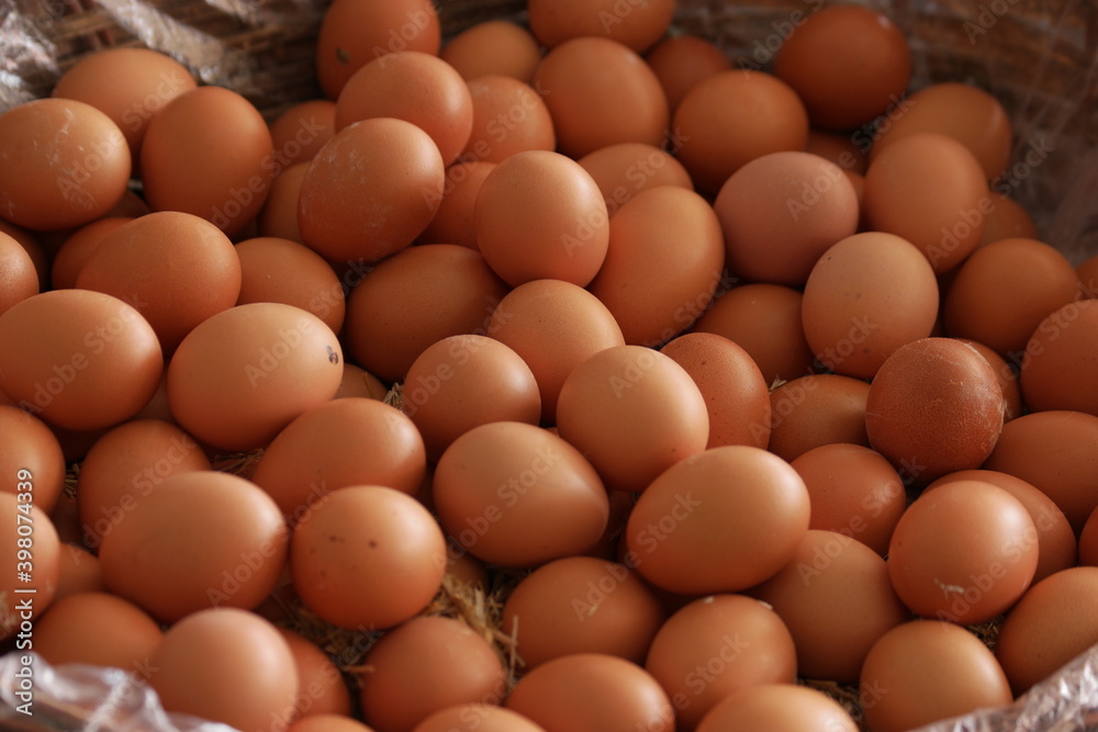 Pile of brown organic eggs at farmers market. Sale of domestic chicken eggs close up. Food industry. Pile of brown organic eggs at farmers market. Sale of domestic chicken eggs close up. Food industry.