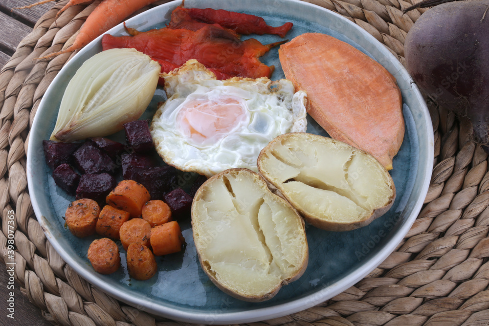 combinated dish with fried egg beet carrots potatoe onion and paprika