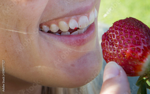 Girl eating a strawberry. Summer fruit. 