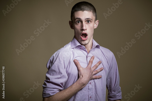 Young casual handsome male becoming shocked, studio photography