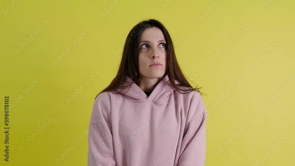 I am afraid. Frustrated frightened young woman in hooded sweatshirt, feeling fear, looks scared, scared, panic attack. closed isolated on yellow background I am afraid. Frustrated frightened young woman in hooded sweatshirt, feeling fear, looks scared, scared, panic attack. closed isolated on yellow background