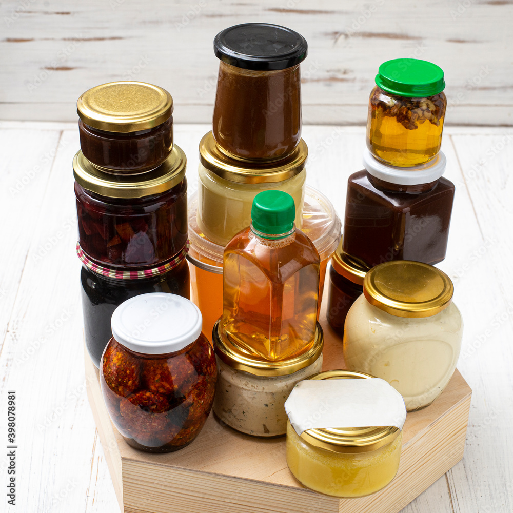 Various canned foods in jars on a light wooden background. Organic food. Various canned foods in jars on a light wooden background. Organic food.