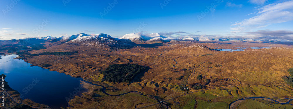 aerial drone view of the loch tulla and bridge of orchy area in the argyll region of the highlands of scotland during autumn on a clear bright day showing calm waters on the inland loch