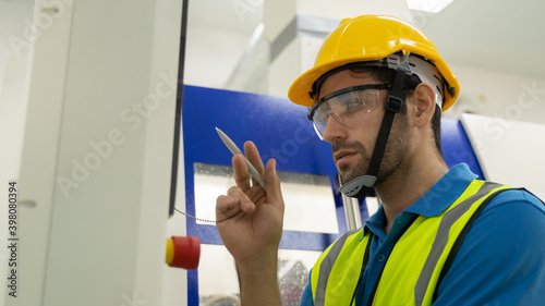 Engineer inspecting and checking operating process on machine monitor.
