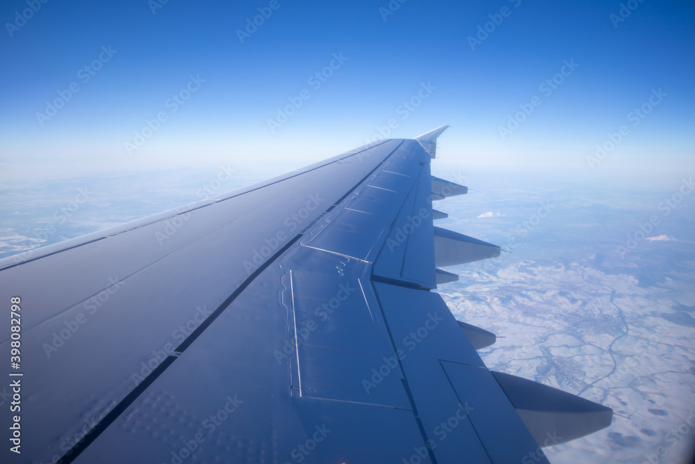 Airplane wings flying in midair and view of clouds in the sky Airplane wings flying in midair and view of clouds in the sky