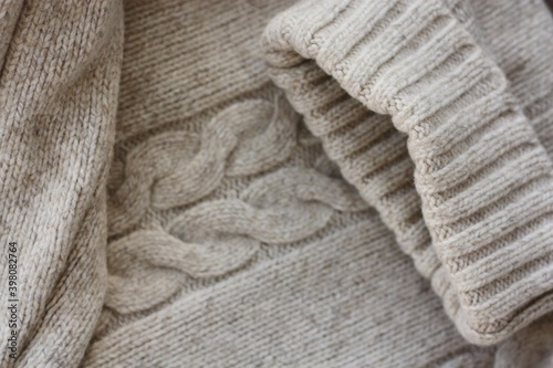 Beautiful beige knitted sweater close up view 