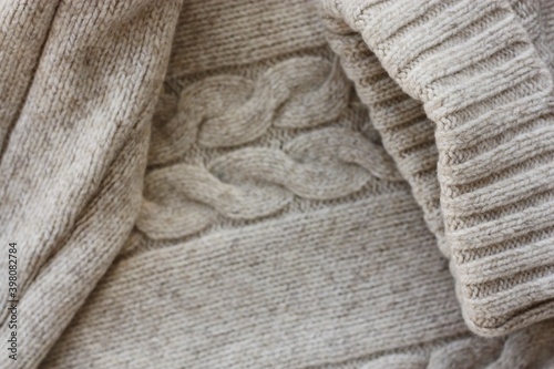 Beautiful beige knitted sweater close up view 