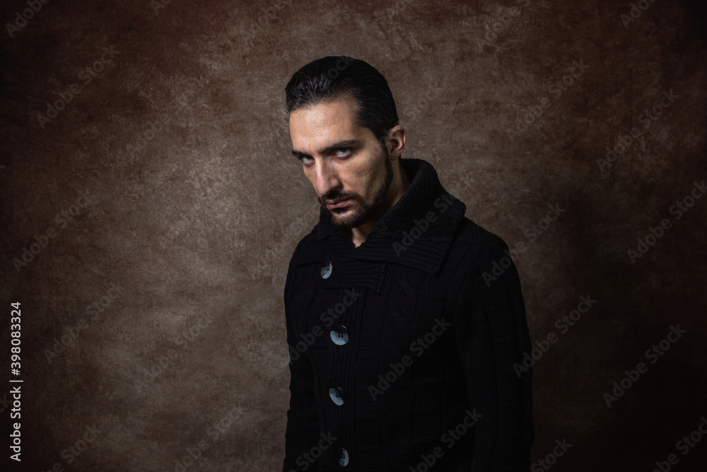 Portrait of a man. evil look. guy in a black sweater. Portrait on a brown background. Portrait of a man. evil look. guy in a black sweater. Portrait on a brown background.