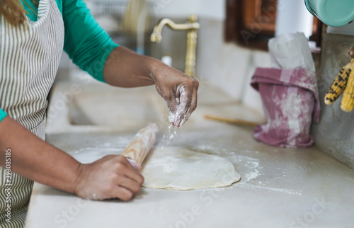Mature latin woman with rolling pin and dough bake in vintage kitchen - Homemade food