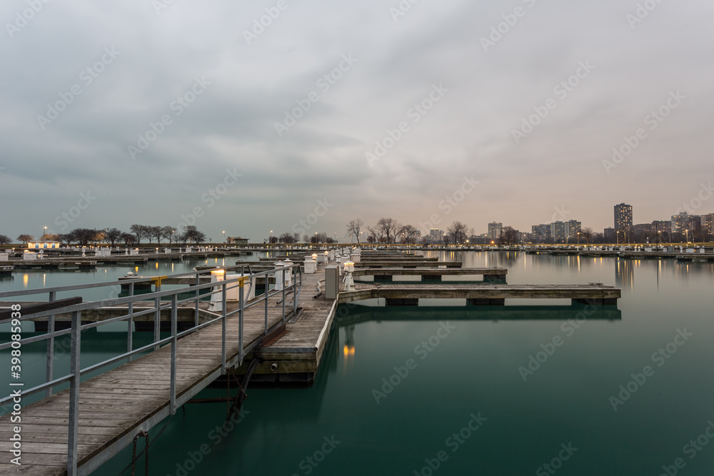 Wooden walkway leading to empty boat docks with cloudy sky in Chicago