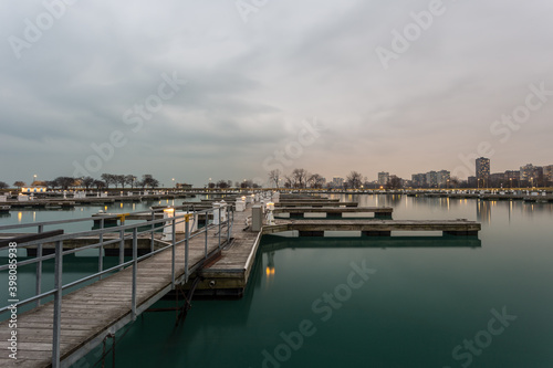 Wooden walkway leading to empty boat docks with cloudy sky in Chicago © Richard