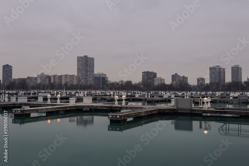Highrise apartment buildings on overcast day behind empty boat docks on calm water in Chicago © Richard