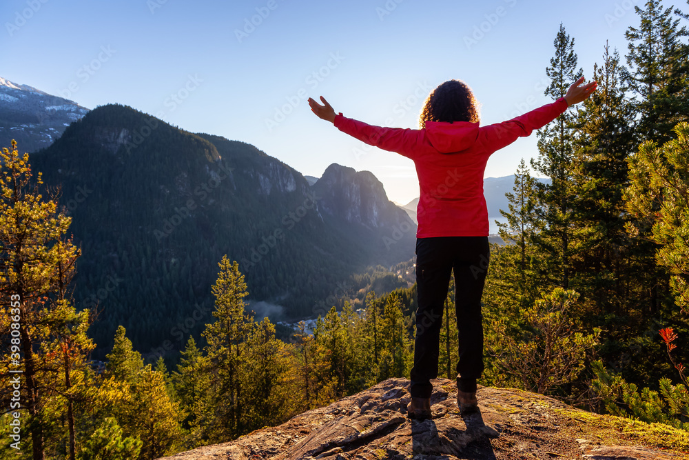 Adventurous Girl Hiking in the mountains during a sunny Autumn Sunset. Taken Squamish, North of Vancouver, British Columbia, Canada. Concept: Adventure, freedom, lifestyle
