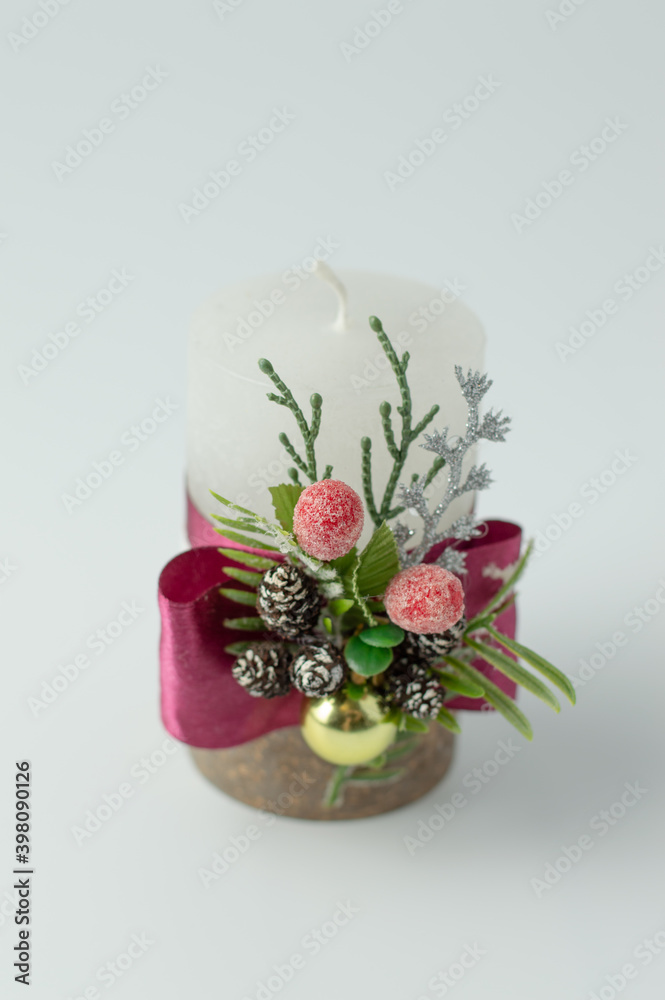 The candle is decorated with decorations for the Christmas holiday.