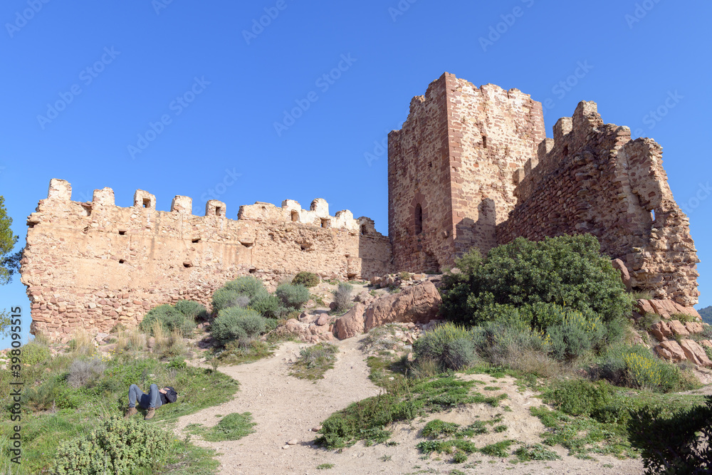 Persona descansando junto a las ruinas del castillo de Serra, en la provincia de Valencia. Comunidad Valenciana. España. Europa