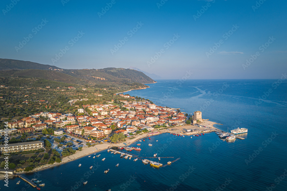 Aerial drone view of iconic medieval seaside town of Ouranoupolis featuring famous tower, Halkidiki, North Greece