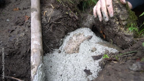 Worker puts rock into fresh concrete