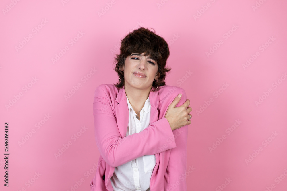 Young business woman over isolated pink background with pain on her shoulder and a painful expression Young business woman over isolated pink background with pain on her shoulder and a painful expression