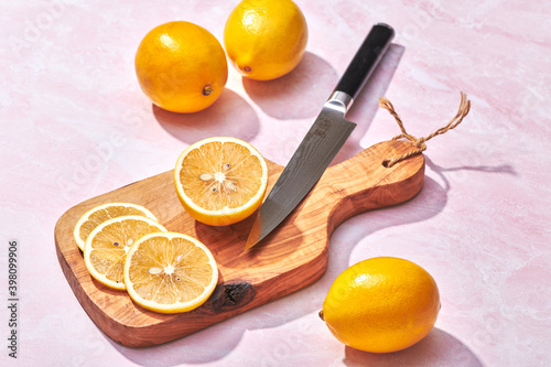 Φωτογραφία Slicing Meyer Lemons on Cutting Board on Pink Marble