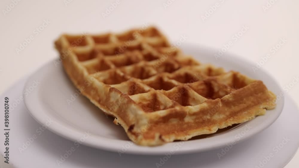 Sprinkle icing sugar over a Belgian waffle - food photography Sprinkle icing sugar over a Belgian waffle - food photography