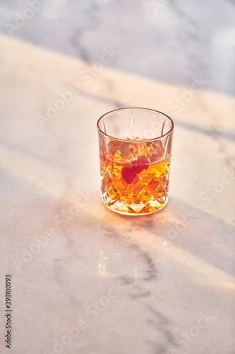 Cocktail Glass with Whiskey or Brown Liquor on Bright Table