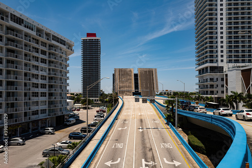 The road rises above the canal. City in Florida in the South of the USA. Road, cars and buildings. City life. photo