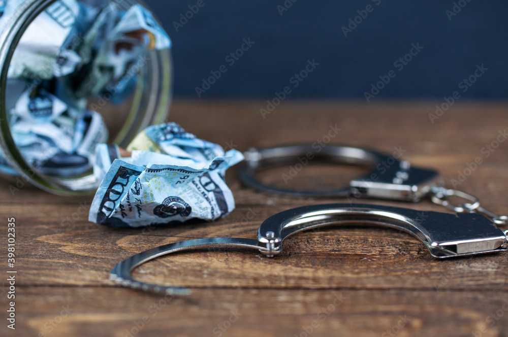 crumpled dollars and open handcuffs crumpled dollars and open handcuffs