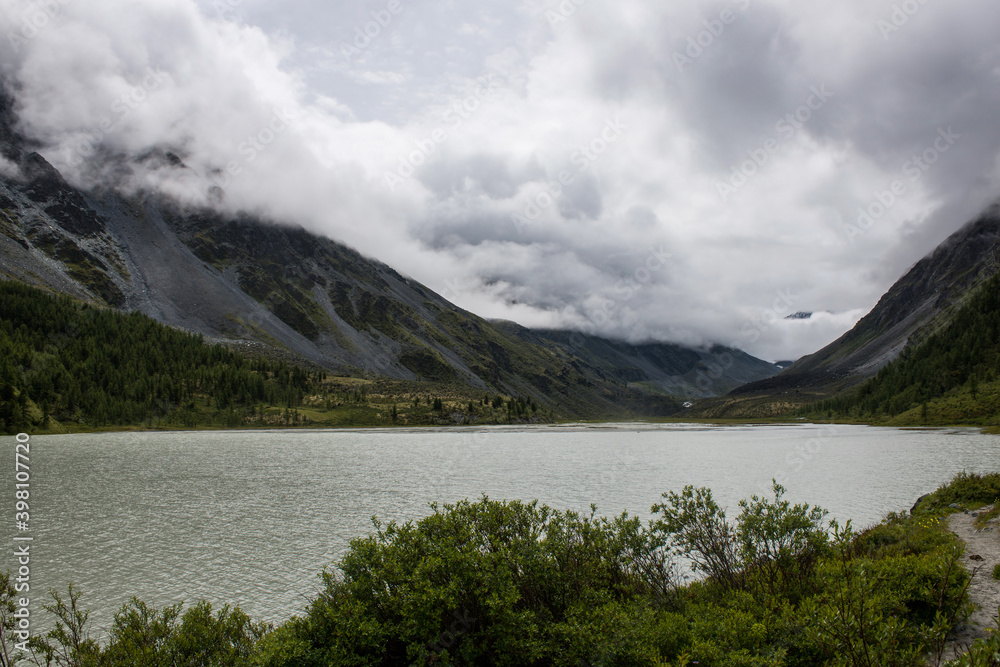 high mountain lake Akkem with mountains shrouded in clouds