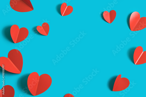 Festive background with red paper hearts on a bright blue background for Valentine's Day. Flatlay. Top view. Copyspace.